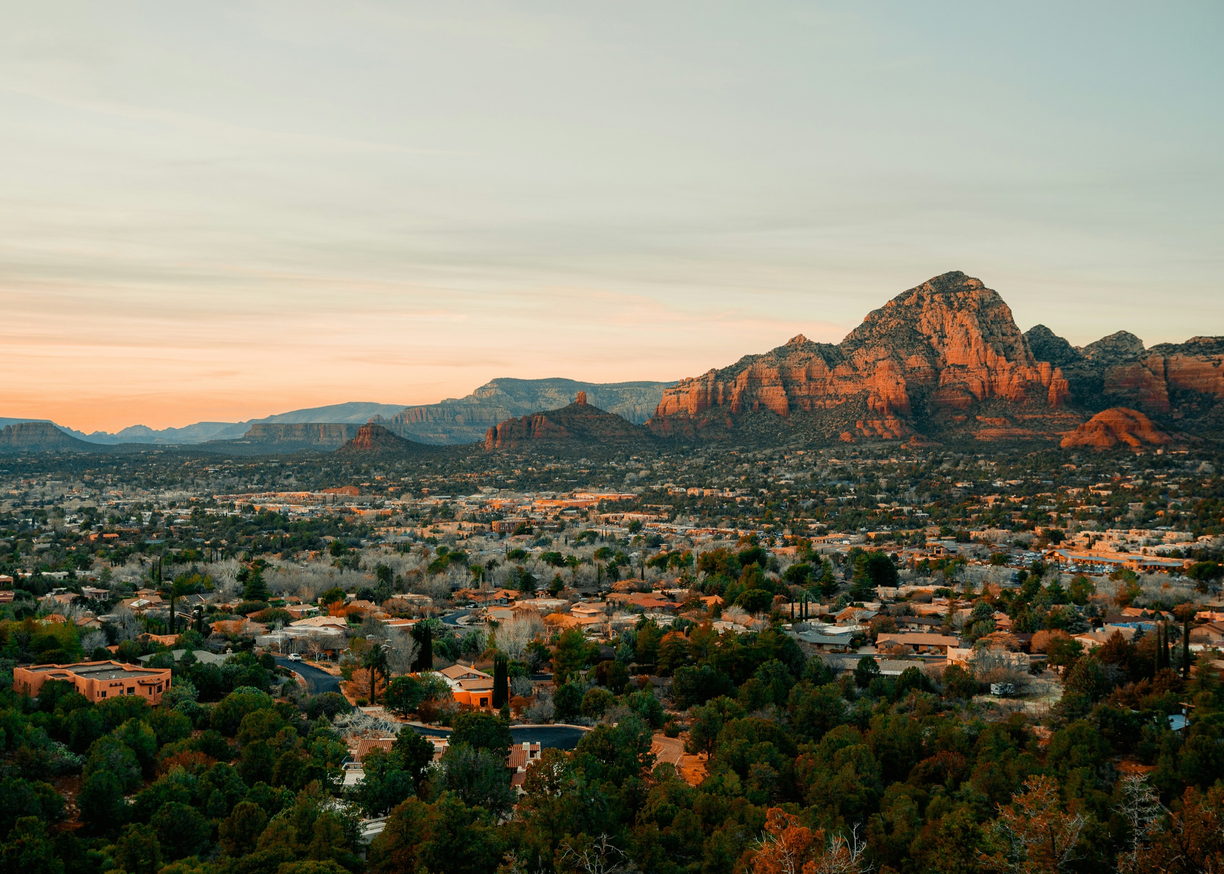 Sedona cityscape at dusk — residential neighborhoods with red rock in the distance