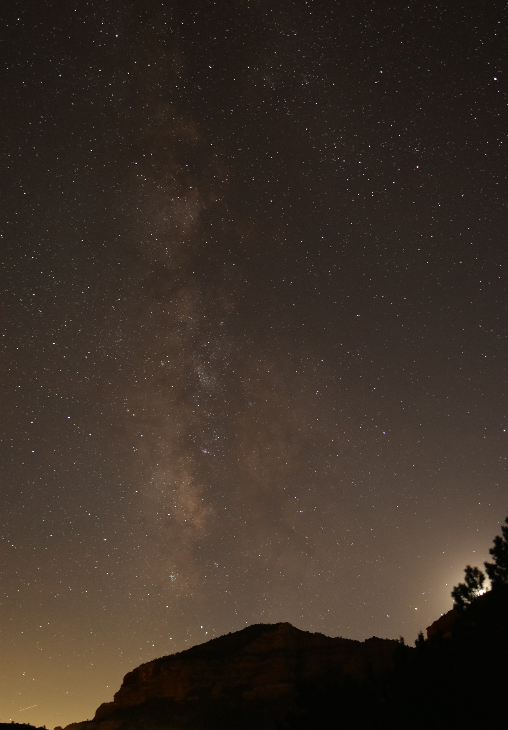 Milky Way rising over a red rock silhouette at night